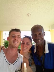 two men and a woman posing for a picture at Leslies' Home in Portmore