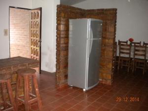 nevera en una habitación con pared de ladrillo en Chalet Carlos Paz en Villa Carlos Paz