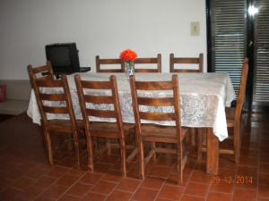 una mesa de comedor con sillas y un jarrón de flores en Chalet Carlos Paz en Villa Carlos Paz