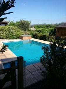 una gran piscina azul con una valla en Cabañas del Dique Frente al Lago, en Villa del Dique