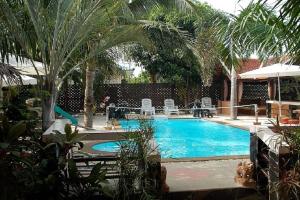 a swimming pool with palm trees and chairs in a yard at Bee Nat Garden Resort in Bangrak Beach