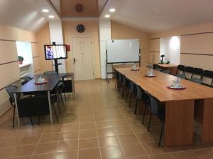a conference room with tables and chairs and a whiteboard at Severniy Hotel in Ukhta