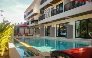 a swimming pool in front of a building at Amarina Green in Lamai