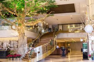 una escalera de caracol en un centro comercial con un árbol en Maayo Hotel en Cebú
