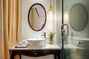 ein Badezimmer mit Waschbecken und Spiegel in der Unterkunft The Herriott Hotel & Suite in Đà Nẵng