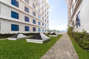 a row of beds on the grass in front of a building at Maayo Hotel in Cebu City