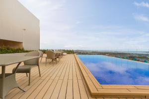 una terraza con mesa y sillas y una piscina en Maayo Hotel en Cebú