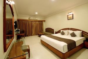 a hotel room with a bed and a desk at Hotel AGC in Aurangabad