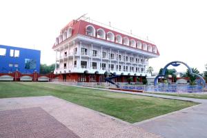un gran edificio con un campo de césped delante de él en Hotel AGC, en Aurangabad
