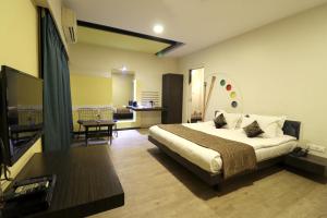1 dormitorio con 1 cama y sala de estar en Hotel AGC, en Aurangabad
