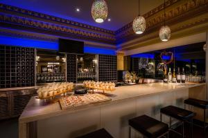 a bar with a counter with food and bottles of wine at Treasury on Collins Apartment Hotel in Melbourne