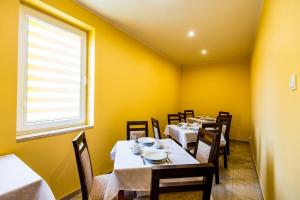 a dining room with tables and chairs and a window at Park Hostel in Suchedniów