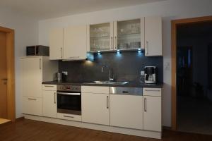una cucina con mobili bianchi e un lavello di Haus Panoramablick a Zellberg