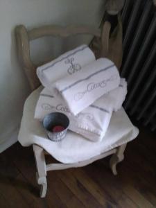 une pile de serviettes blanches assises sur une chaise dans l'établissement Mme Teurtroy, Chambres d'Hôtes La Prairie, à Gouesnach