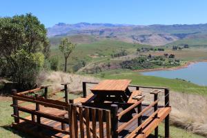 a picnic table with a view of a river and mountains at Treks, Trips and Trails in Champagne Valley