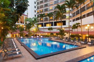 a large swimming pool with chairs and a building at York Hotel in Singapore
