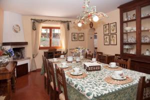 a dining room with a table with chairs and a chandelier at Villa degli Scoiattoli in SantʼElpidio a Mare
