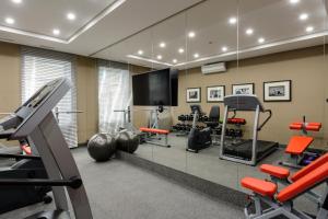 a gym with a mirror and some exercise equipment at Hotel Senator in Karagandy