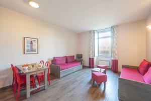 a living room with pink furniture and a table at Résidence Pierre & Vacances Le Fort de la Rade in Île dʼAix