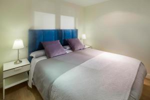 マラガにあるINMálaga Victoriaのベッドルーム1室(大型ベッド1台、紫色の枕付)