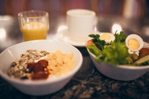 uma mesa com duas tigelas de comida e um copo de sumo de laranja em Hotel Anna em Helsinque