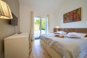 a bedroom with a bed and a table and a window at Villa Adriana in Risika +25 photos