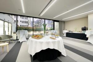 a room with a table with a bowl of fruit on it at Eurostars Book Hotel in Munich