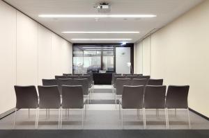 a conference room with black chairs and a podium at Eurostars Book Hotel in Munich