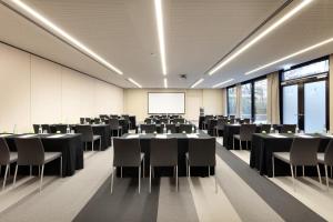 a conference room with tables and chairs and a whiteboard at Eurostars Book Hotel in Munich