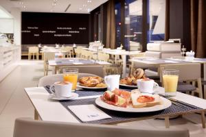 a table with two plates of pastries and orange juice at Eurostars Book Hotel in Munich