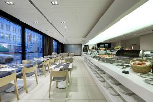 een eetkamer met tafels en stoelen en een cafetaria bij Eurostars Book Hotel in München