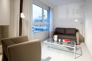 a living room with a couch and a glass table at Eurostars Book Hotel in Munich
