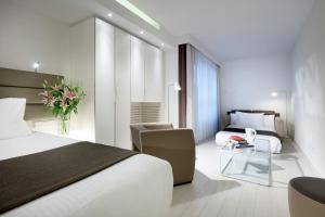 a hotel room with a bed and a living room at Eurostars Book Hotel in Munich