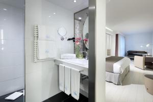 a bathroom with a sink and a bed in a room at Eurostars Book Hotel in Munich