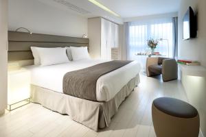 a hotel room with a large bed and a chair at Eurostars Book Hotel in Munich