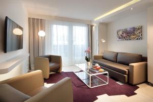a living room with a couch and a table at Eurostars Book Hotel in Munich