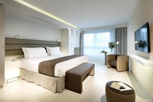 a hotel room with a bed and a chair at Eurostars Book Hotel in Munich +37 photos