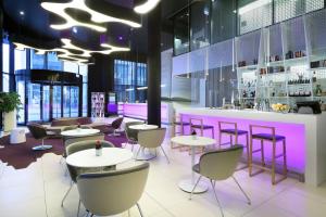 a restaurant with tables and chairs and a bar at Eurostars Book Hotel in Munich