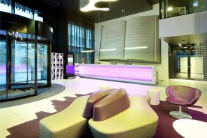a lobby with a bench and chairs in a building at Eurostars Book Hotel in Munich