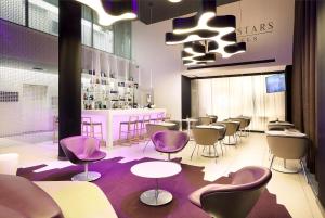 a restaurant with chairs and tables and a bar at Eurostars Book Hotel in Munich