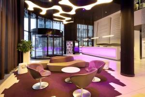 a lobby with a couch and a table and chairs at Eurostars Book Hotel in Munich