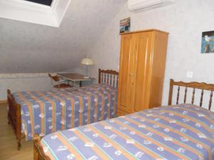 1 Schlafzimmer mit 2 Betten und einem Holzschrank in der Unterkunft Meuble de la Tour in Nogent-sur-Seine