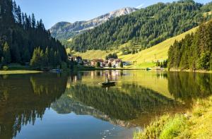 eine Person in einem Boot auf einem See mit Bergen in der Unterkunft Privatzimmervermietung Wiederkehr in Altenmarkt im Pongau
