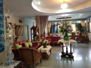 a living room with a vase of flowers on a table at Wiang Inn Mansion in Chiang Mai