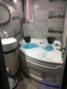 a bathroom with a bath tub and a sink at Comfort Home Apartment 1 in Petroşani