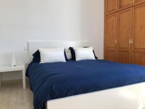 プラヤ・オンダにあるAires de Marのベッドルーム(青いシーツ、白い枕付)