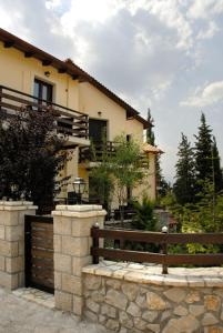 une maison avec une porte en bois et une clôture dans l'établissement Dryas Guesthouse, à Polydrossos