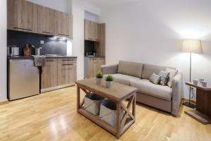 a living room with a couch and a table and a kitchen at Brzeće Center Apartments in Kopaonik