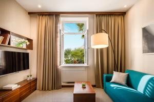 a living room with a blue couch and a window at Villa Elizabeta Apartments in Opatija
