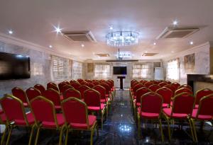 a conference room with red chairs and a chandelier at Valley Front View Hotel in Ikeja